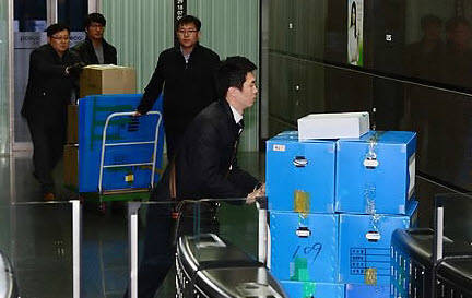 지난 13일 포스코건설을 압수수색한 검찰 수사관들이 압수된 서류 등을 옮기고 있다.